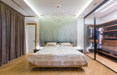 A wide view of a bedroom with a sliding door wardrobe