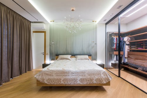 A wide view of a bedroom with a sliding door wardrobe