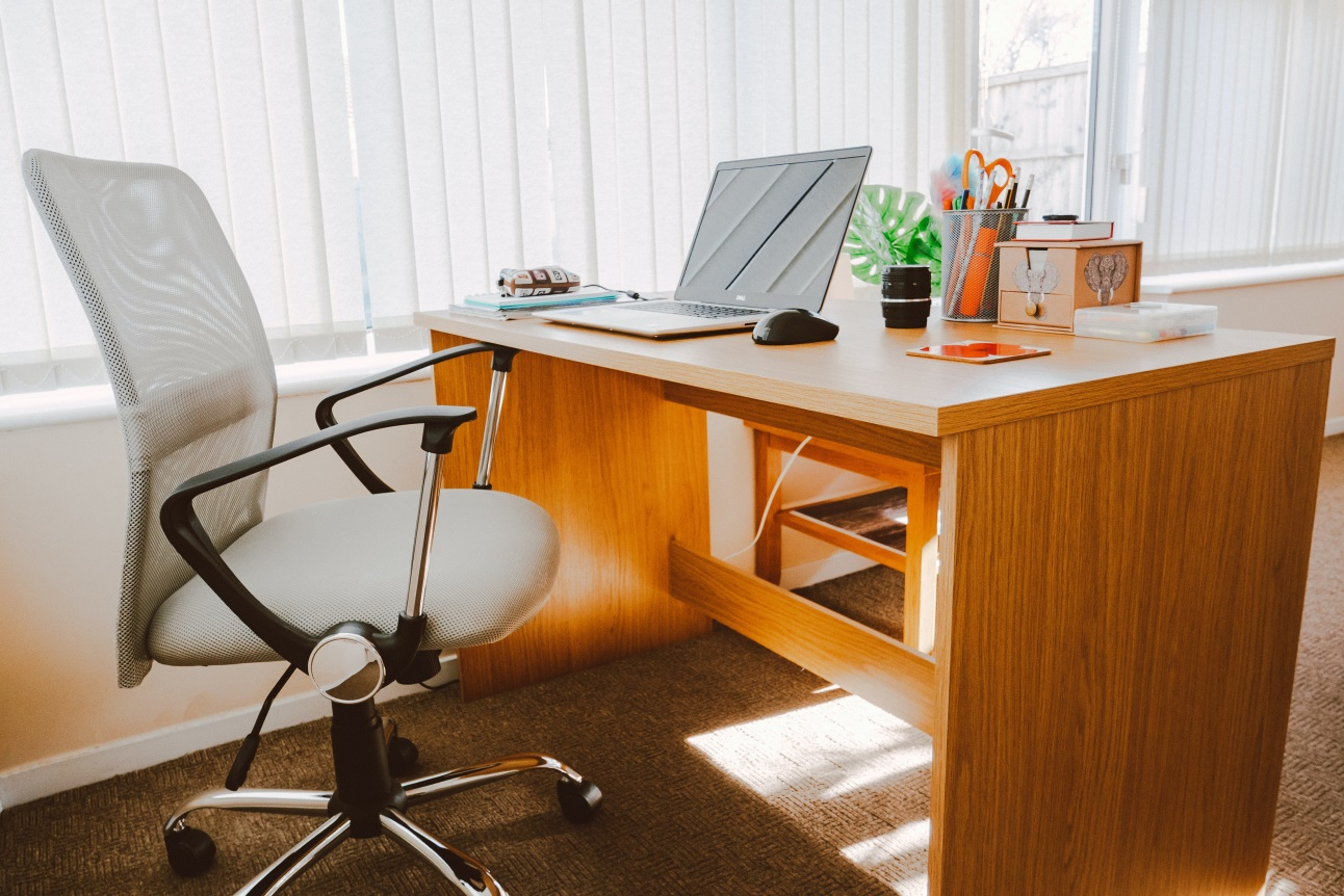 A white rolling armchair placed beside an office table